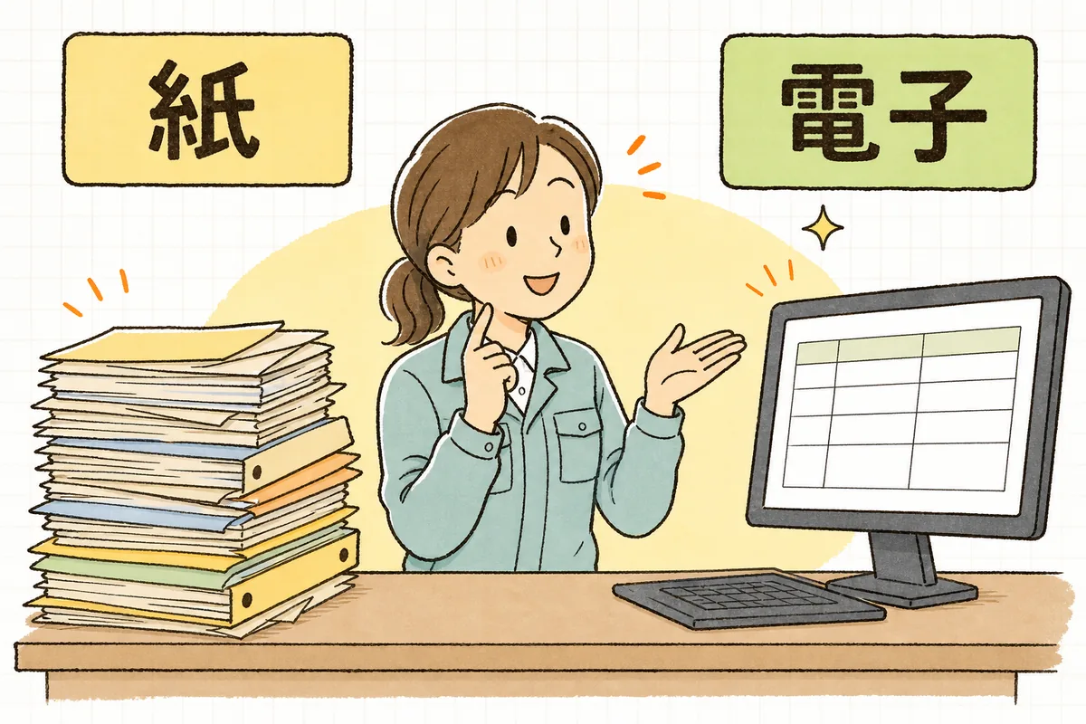 紙のファイルとパソコン画面を並べて、紙は手元保管・電子はシステム保管という違いを確かめる産廃の事務担当者
